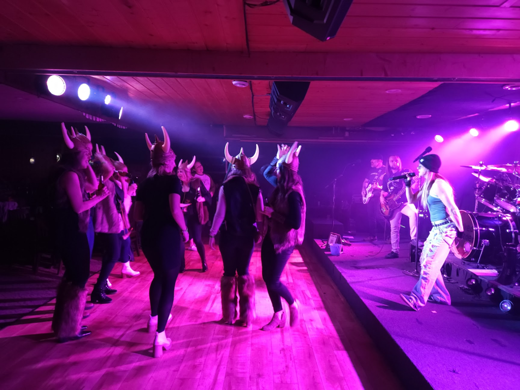 A bachelorette party dances while wearing viking helmets